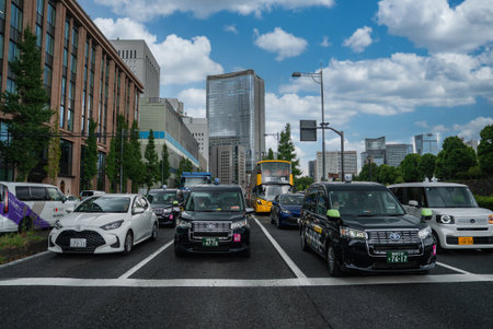 Tokyo boulevard with cars and black taxis at signal in Marunouchiの写真素材