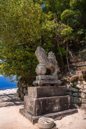 Weathered stone komainu on path at Itsukushima Island, Hiroshimaの写真素材