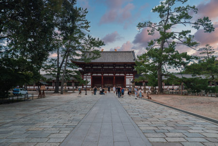 Stone walkway to grand temple gate with deer and tourists in Naraの写真素材