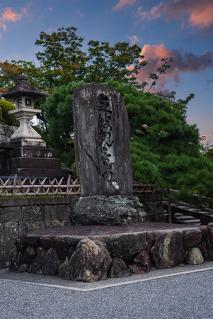 Stone stele and lantern at temple entrance in Kyoto at duskの写真素材