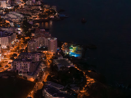 Aerial night view of Funchal coastal district with turquoise poolの写真素材