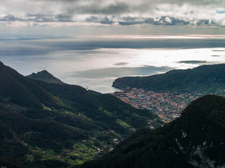 Aerial Madeira north coast bay, terraced slopes, and Atlantic headlandの写真素材