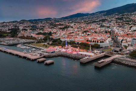 Aerial dusk view of Funchal harbor, fairground, and hillside cityの写真素材