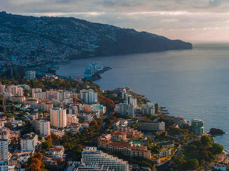 Funchal coastal view with cruise ship and Cabo Girao in warm lightの写真素材