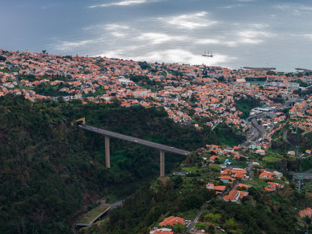 High bridge spans ravine toward harbor in Funchal, Madeira, Portugalの写真素材
