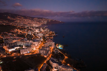 Evening aerial of Funchal, Madeira with lights across terraced hillsの写真素材