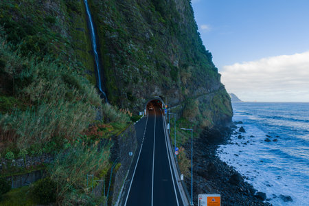 Aerial tunnel road by cliff and waterfall on Madeira north coastの写真素材