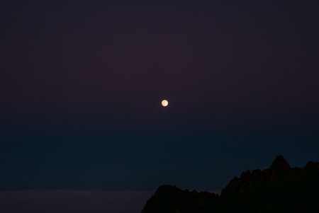 Full moon over twilight sky and mountain ridge in Madeira, Portugalの写真素材
