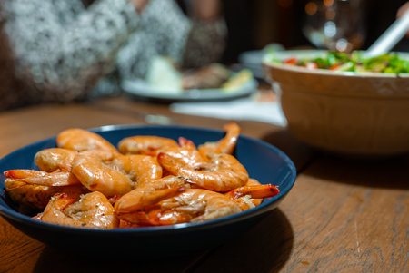 Shrimp in a blue bowl on wooden table, Funchal dining sceneの写真素材