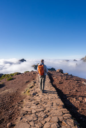 Hiker on stone trail between Pico do Arieiro and Pico Ruivo, Madeiraの写真素材