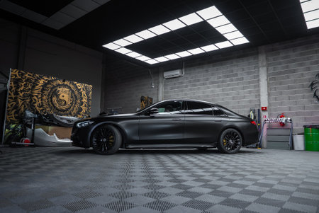 Matte black S Class in studio with lion mural and gear