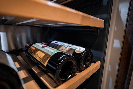 Two premium wine bottles on wooden slats inside a built in cooler