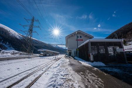 Winter alpine train station in Zermatt with sun flare and tracks