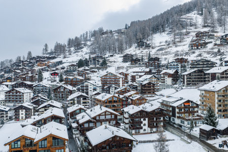 Winter resort village in Zermatt with chalets on a wooded hillside