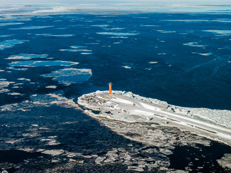 Aerial winter view of Mangalsala Lighthouse at icy breakwater in Rigaの写真素材