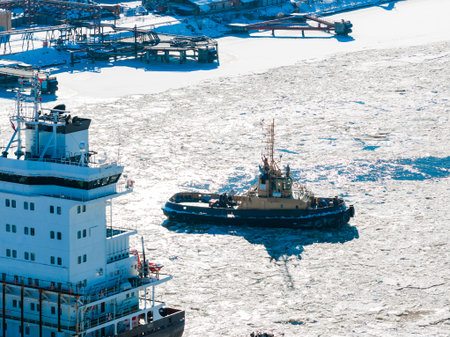 Aerial winter view of Riga Shipyard tug breaking ice on Daugavaの写真素材