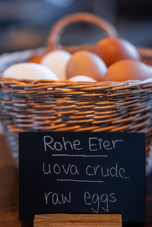 Wicker basket of brown and white eggs with chalkboard