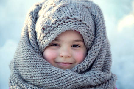 Portrait of a little girl in a headscarf in winter.の写真素材