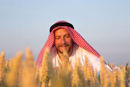 Arab man in a wheat field. A Muslim rejoices in a wheat field.の写真素材