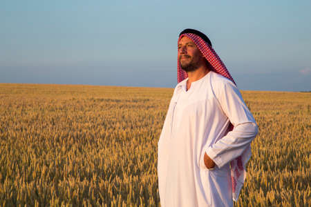 Arab man in a wheat field. A Muslim rejoices in a wheat field.の写真素材