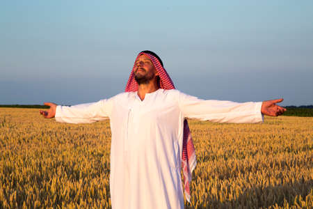 Arab man in a wheat field. A Muslim rejoices in a wheat field.の写真素材