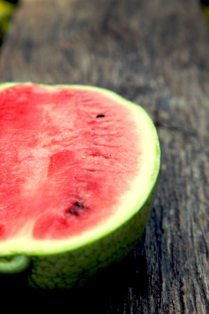 Juicy fresh red watermelon on the table. Watermelon sliced into pieces on a wooden texture background. The concept of food, happiness, sweets and desserts.の写真素材