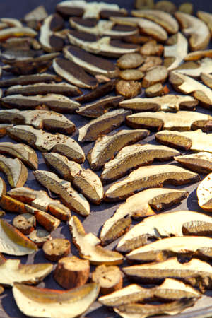 Sliced porcini mushrooms before drying. Sliced dried natural porcini mushrooms on a wood background....