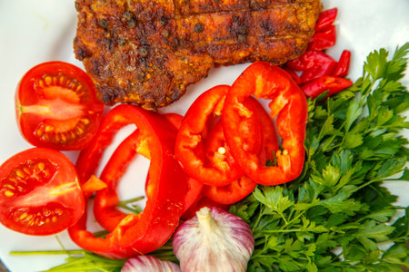 Meat steak cooked on the barbecue. Grilled fresh meat steak with spices and red pepper. Ready steak on the table with tomatoes and peppers. The concept of food, restaurants, traditionの写真素材