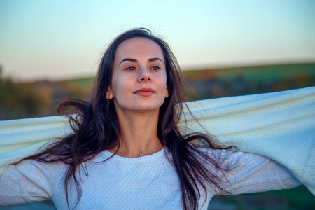 Young happy woman outdoors in autumn. Portrait of a girl's face on a walk in the park. The concept of happiness, freedom, outdoor recreation.の写真素材