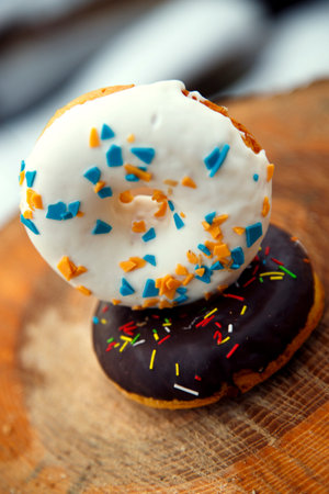 Donuts with sprinkles on a wooden board. Selective focus.