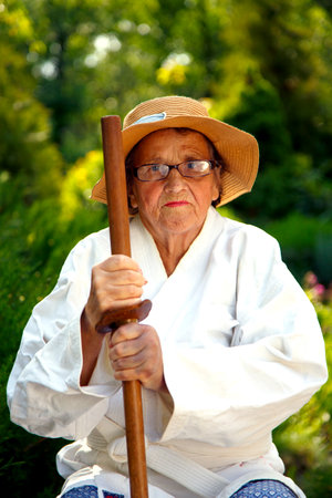 An old lady in a park. Portrait of an old lady training in the garden. The concept of old age, sports, nature.の写真素材