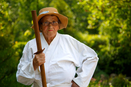 An old lady in a park. Portrait of an old lady training in the garden. The concept of old age, sports, nature.の写真素材