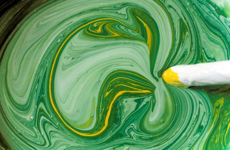 Mixing colours with a stirring stickの写真素材