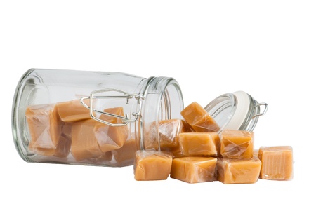 Light brown caramel sweets in a glass, isolatedの写真素材