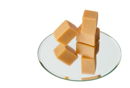 Light brown caramel sweets on a mirror, isolatedの写真素材