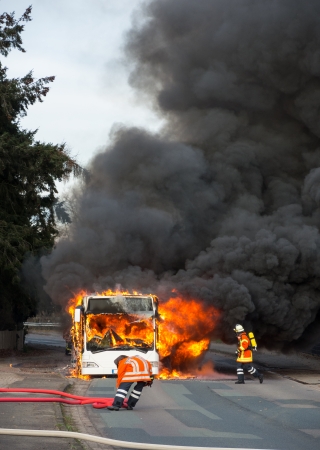 Firefighters extinguish a burning school bus in Sebbenhausen, community Balge, Germanyの写真素材