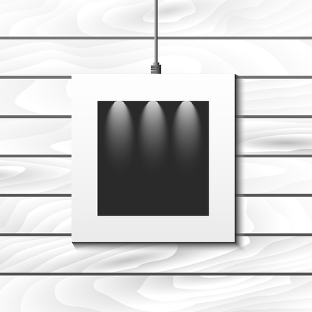 Hanging photo frame for picture placement. Vector white mock up frame with spotlights on white wood wall.のイラスト素材