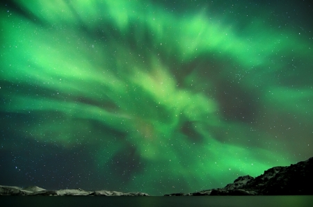 Flash of Aurora polaris above waterの写真素材