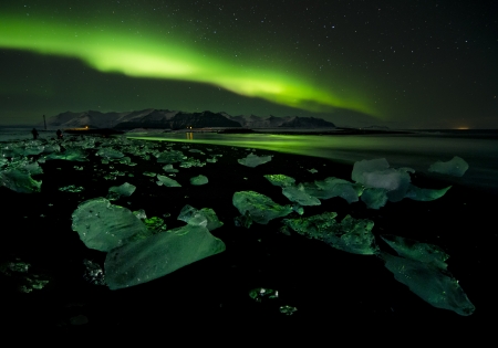 Flash of Aurora polaris above waterの写真素材