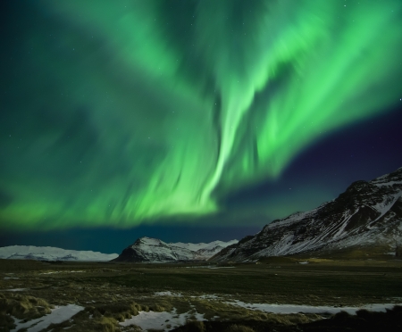 Flash of Aurora polaris above mountainsの写真素材