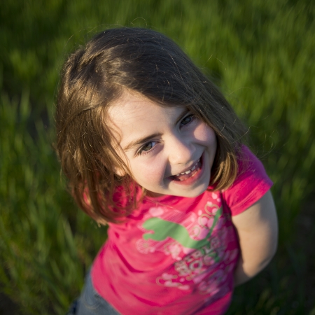 Cute little girl  on the meadow in summer dayの写真素材