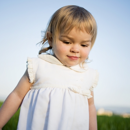 Cute little girl  on the meadow in summer dayの写真素材