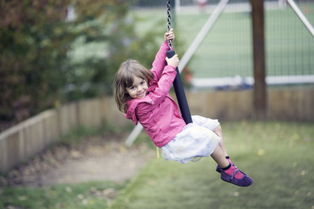 Little girl playing in the zip in a rainy day