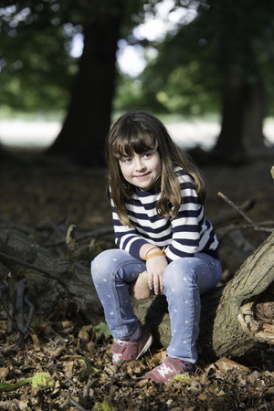 Little  girl in the forest with the last sun raysの写真素材