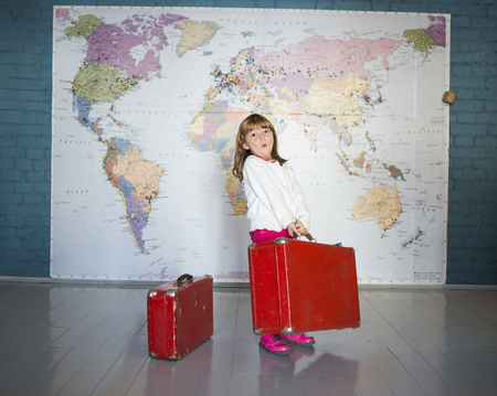 A little girl smiling in front of a world mapの写真素材