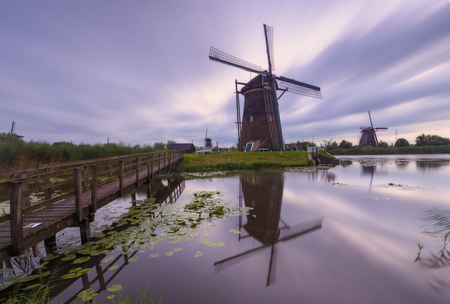 Windmills of Kinderdijk village, Holland, in a cloudy morningの写真素材