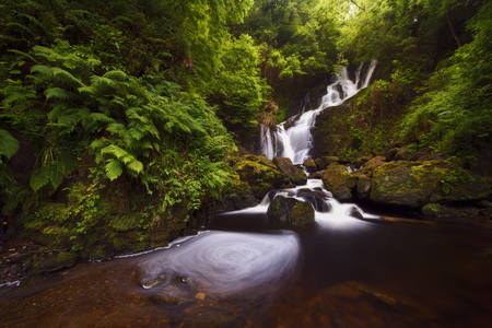 Beautiful waterfall in the middle of the forest, Torc, Irelandの写真素材