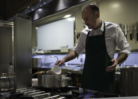 A chef, in his restaurant kitchen, cooking in the stoveの写真素材