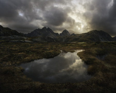 Little lake surrounded by mountains at sunsetの写真素材