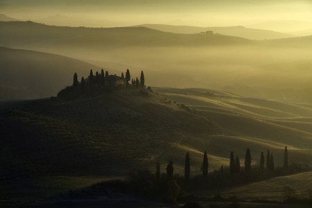 Sunrise over San Quirico D'orcia, Tuscany, in a misty morning of autumnの写真素材
